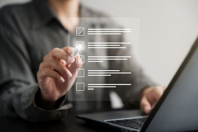 Digitales Baubüro Frau vor einem Laptop, die an einer digitalen Checkliste arbeitet